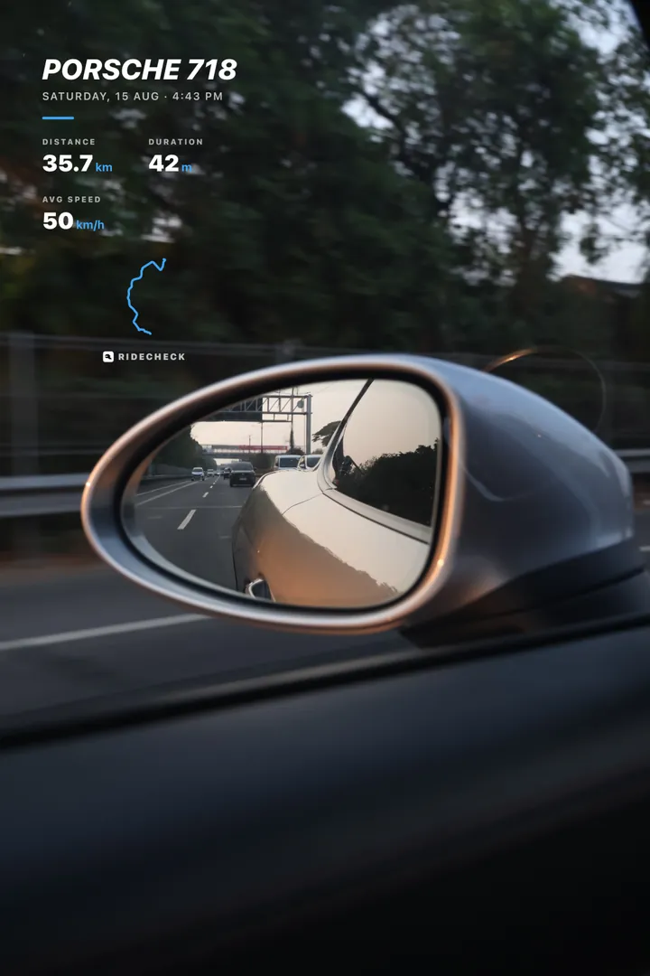 A RideCheck trip sticker over a photo taken through a Porsche 718 wing mirror on the motorway